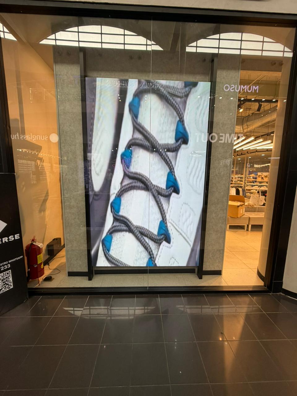 Pantalla LED vertical en la entrada de una tienda en un centro comercial